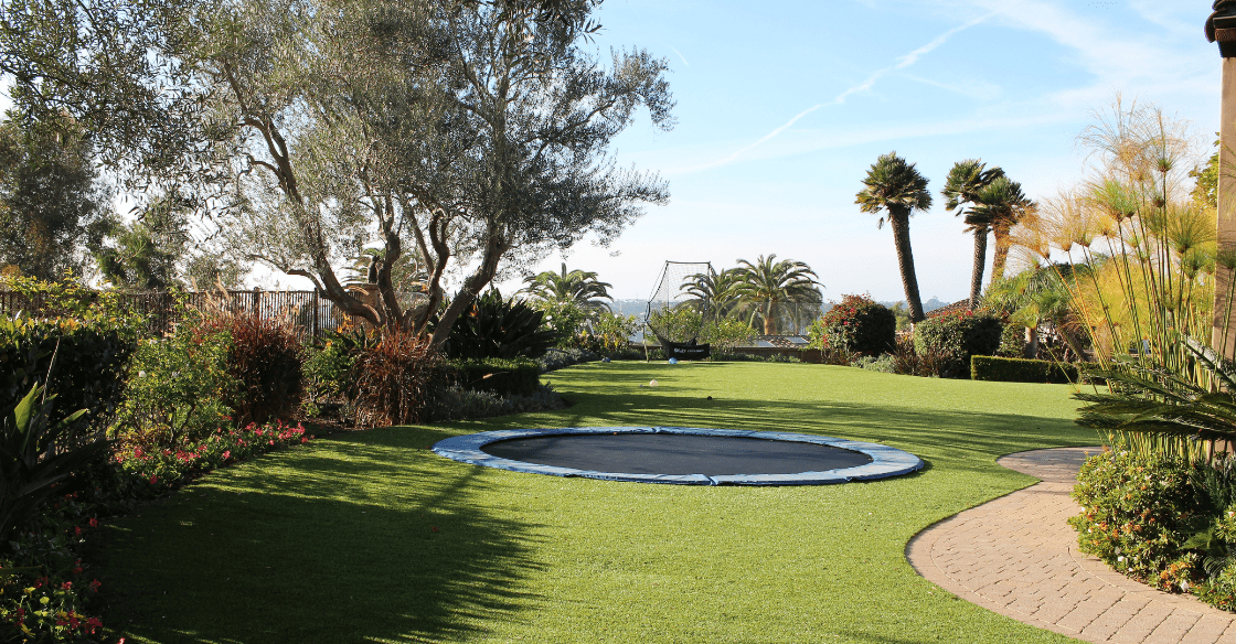 in-ground trampoline surrounded by artificial turf